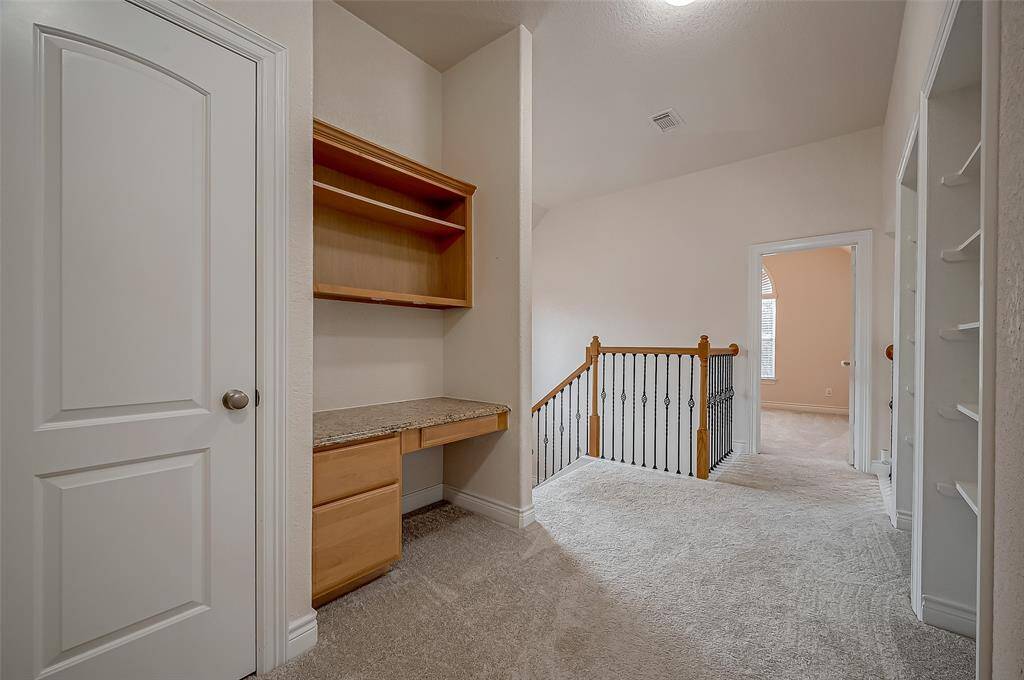 This second floor hallway area features a convenient desk area for homework or a second home office work station.  With ample shelving and drawer storage this versatile space is useful for everyone.