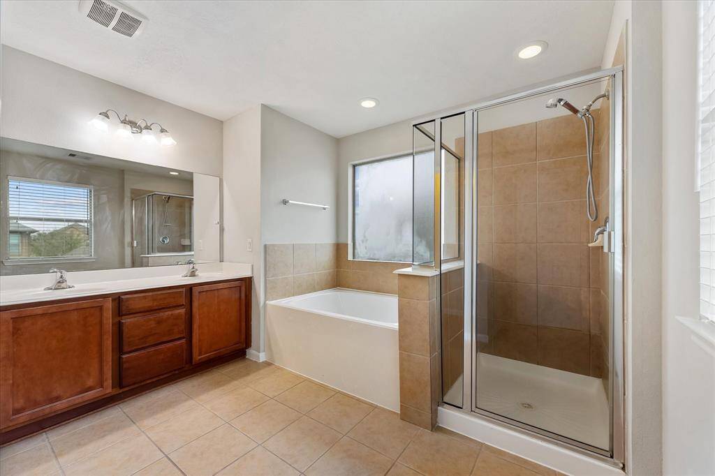 Dual sinks, deep soaking tub and separate shower complete the primary bath
