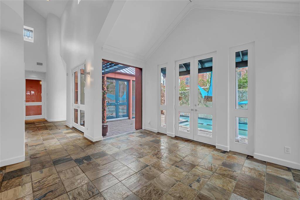 Sunlit dining room featuring a high vaulted ceiling is just off the kitchen.