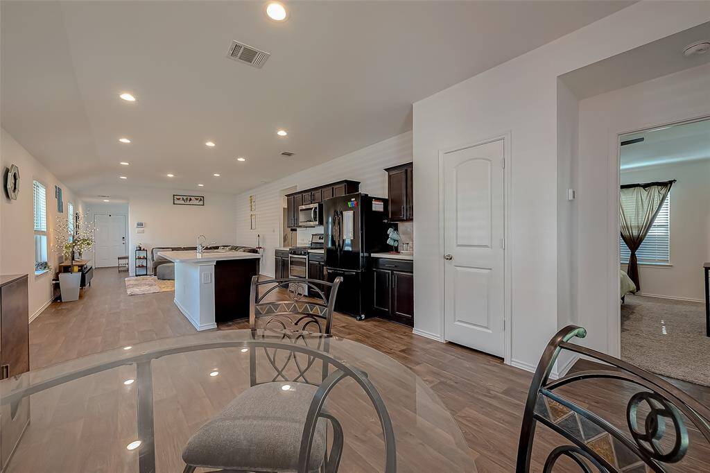 Alternative view of dining room, kitchen, and living area.