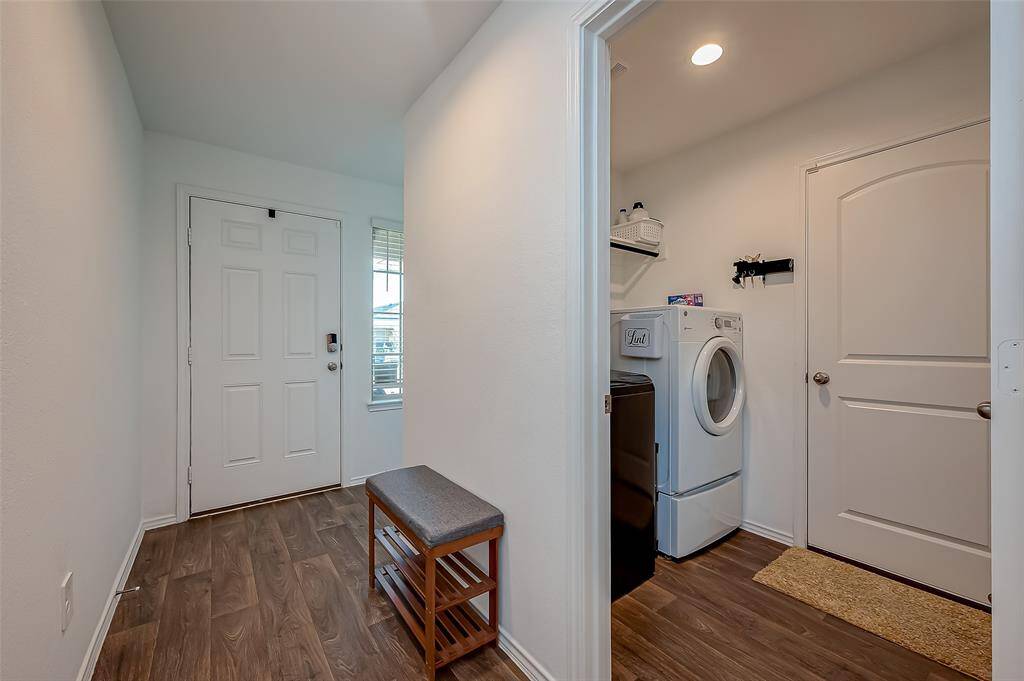 View of front door, hallway, and utility room