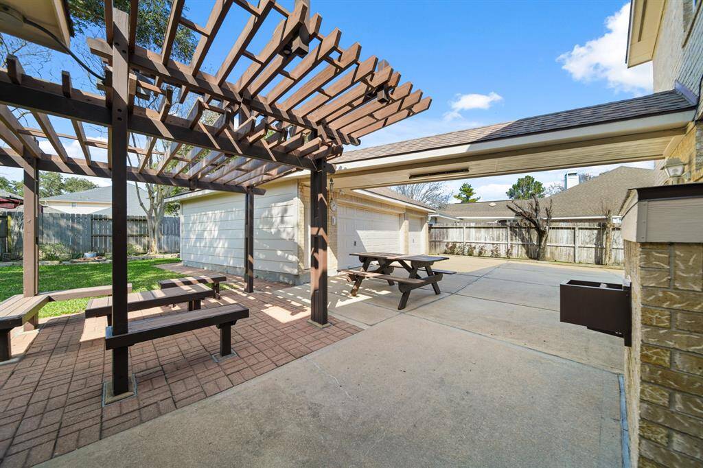 Large backyard with a pergola patio and seating.