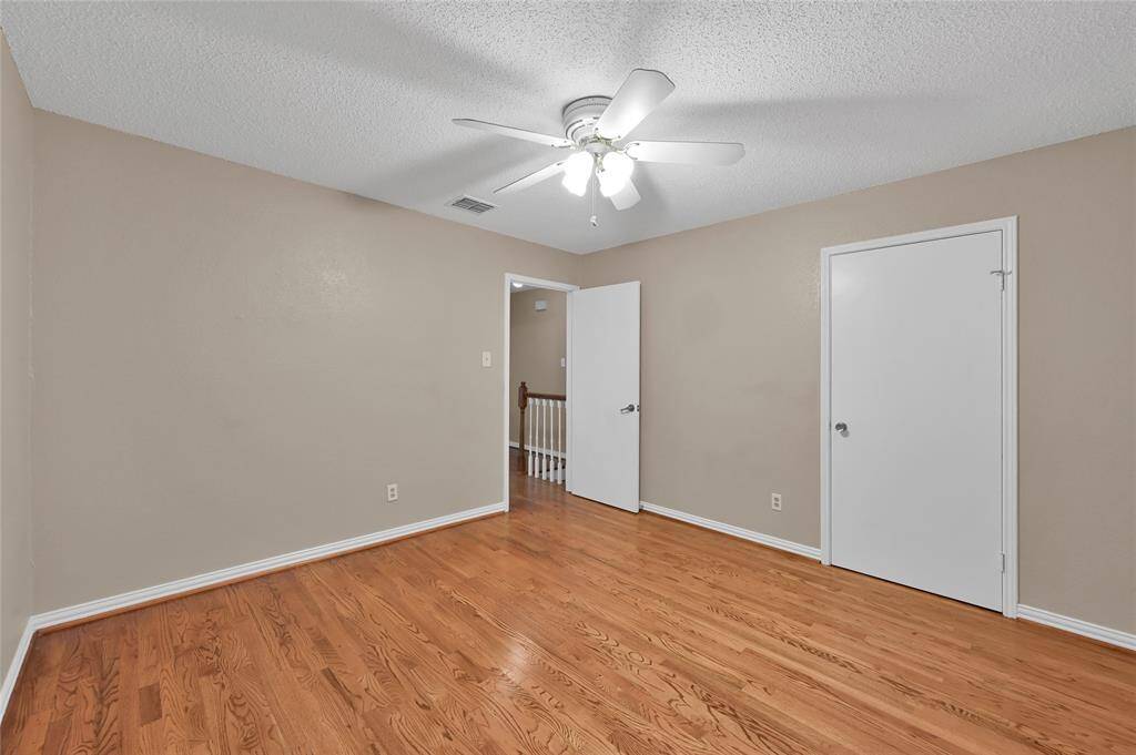 A secondary bedroom featuring hardwood floors and a roomy closet.