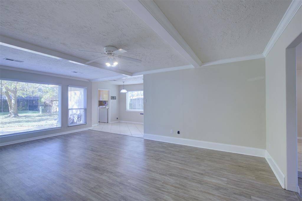 Another view of this large family room with vinyl plank floors and neutral paint! It feel so open with the many windows!