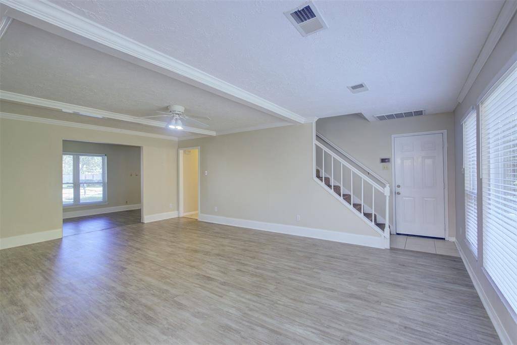 A view of the living room toward the stairs. That door leads to the attached two car garage.