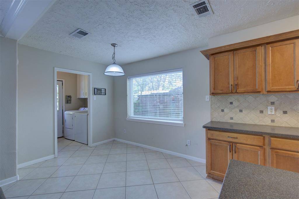 This breakfast room has tile floors and neutral paint. The laundry room is just to the left.