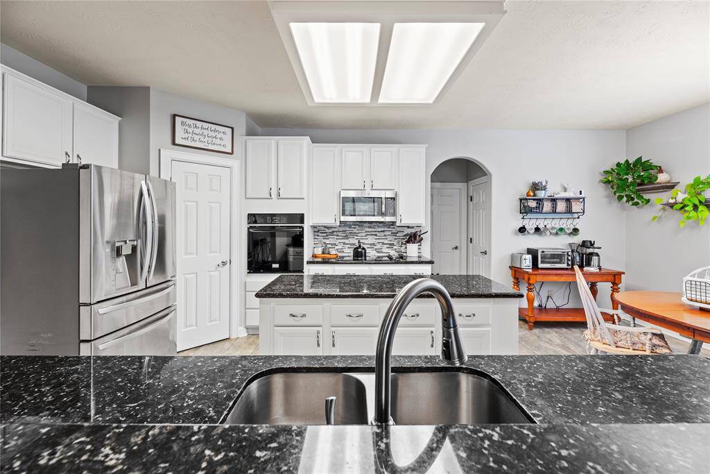 A raised bar separates the kitchen from the family room, creating a seamless connection between spaces. Perfect for serving drinks and snacks, it allows you to stay engaged with family and guests while preparing meals.