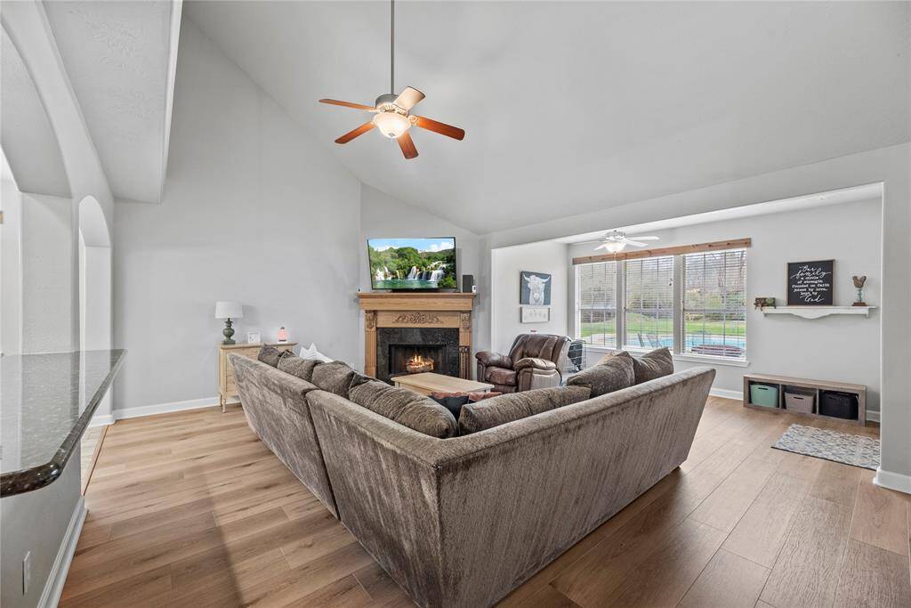 Imagine the sounds of chatter and laughter as you create memories of a lifetime with the people you love. This wonderful open family room is the perfect place to do just that with luxurious vinyl plank floors, soft neutral paint, a soaring ceiling, romantic gas-log fireplace, and adjoining sunroom with picture-perfect views of the sprawling yard and pool.