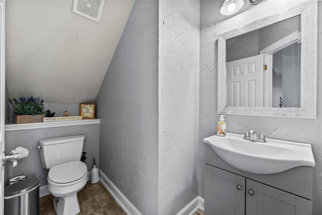 The first-floor powder bathroom is convenient for guests with a single sink vanity with a coordinating mirror and vanity lights above.