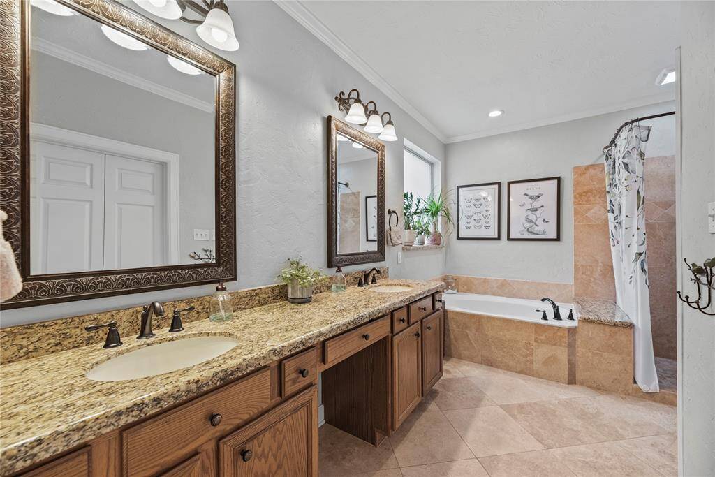 The owner's ensuite bathroom is easy to share with an extended dual sink vanity with matching mirrors and coordinating vanity lights above. You'll even find knee space to sit while you primp.
