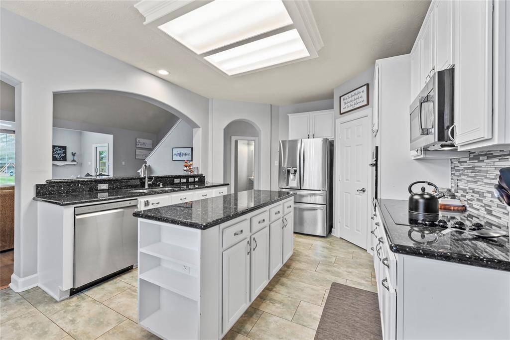 Ditch the takeout and cook from home more often. This fully loaded kitchen offers crisp white cabinetry, sleek granite countertops, designer tile backsplash, stainless steel appliances, and two very large walk-in pantries.