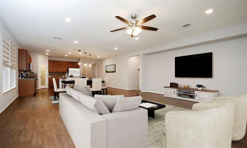 Spacious open living/dining/kitchen. Image is virtually staged