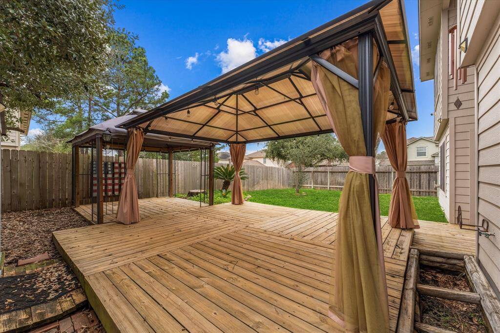 The backyard is a private retreat, complete with two gazebos, a wooden deck, and a storage shed!