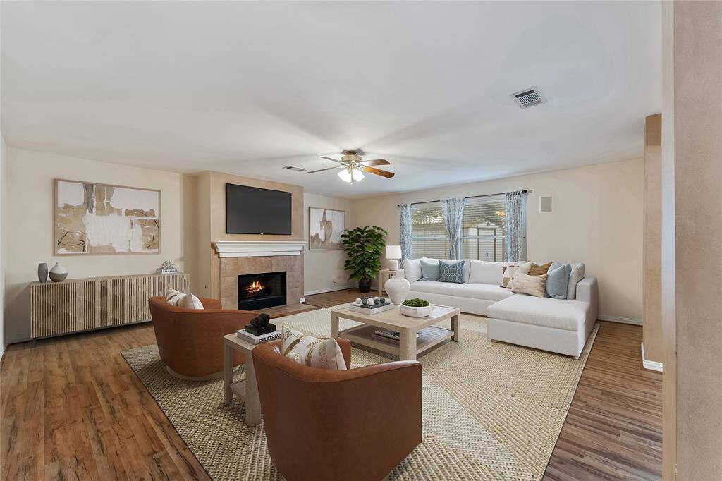 Oversized living room with a wood-burning fireplace that has gas connections. Virtually staged