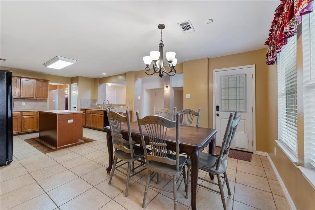 Open concept kitchen and breakfast area with views outside and into the living room.