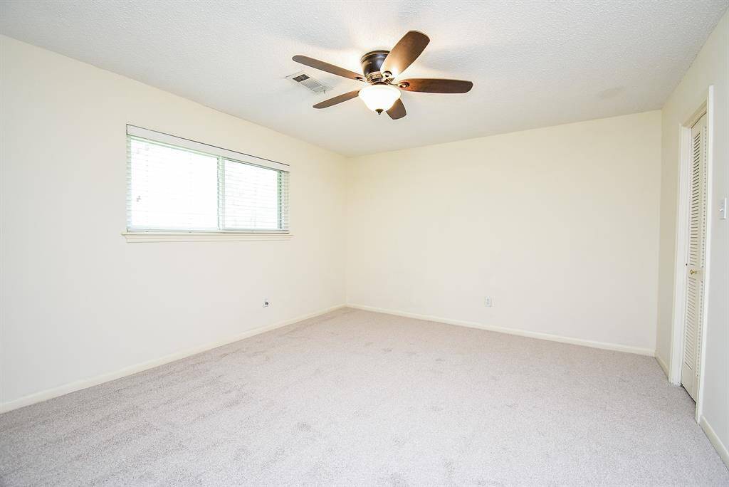 Bedroom 3 with brand new carpet and large walk in closet.  On the opposite wall is a large (removable) shelving unit which was helpful and functional in what was a home office.
