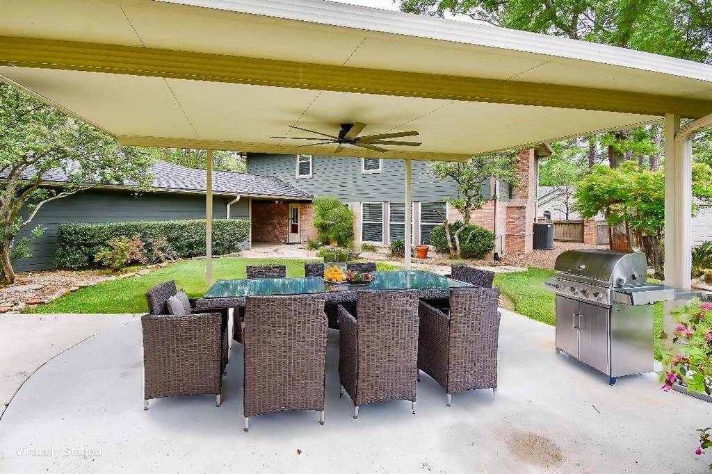 Wow! The backyard as seen from the covered porch looking to the pergola which has a fan , electricity, and a large concrete extension for your grills/smokers or an extra seating area to relax in the sun.