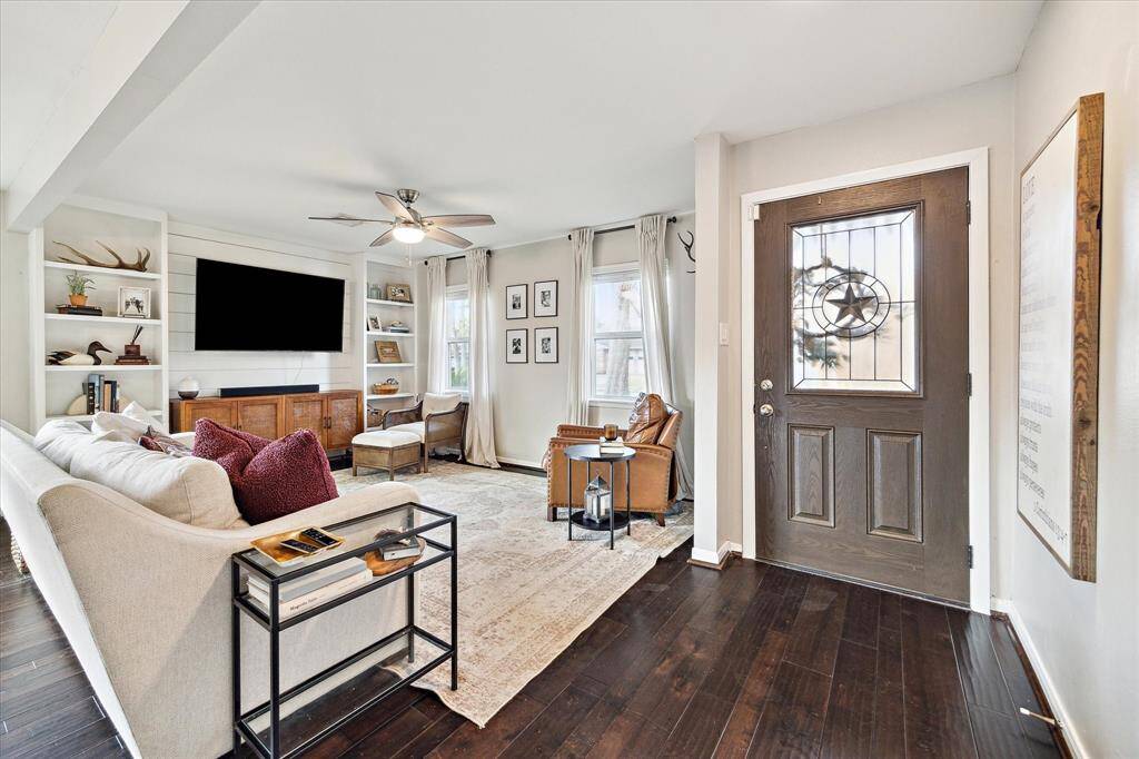 Engineered hardwoods continue throughout the main living areas and primary suite. Note the shiplap detail and built-ins completed by the current owner.