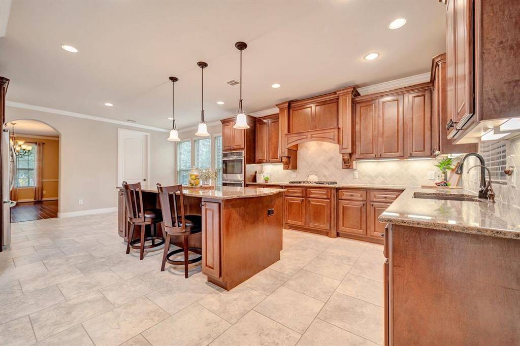 This kitchen features a spacious layout, abundant cabinetry, and plenty of lighting.  Complete with a double oven, gas stove top, microwave and full sized refrigerator.
