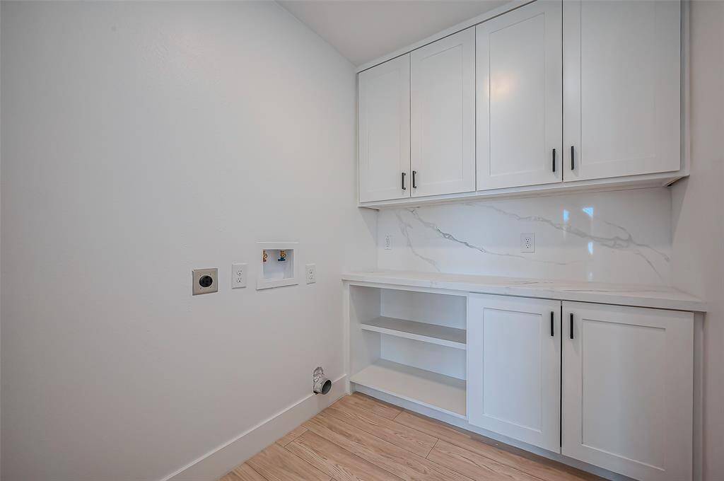 Enjoy the convenience of a newly added utility room, featuring washer and dryer connections along with built-in storage and shelving for optimal organization.