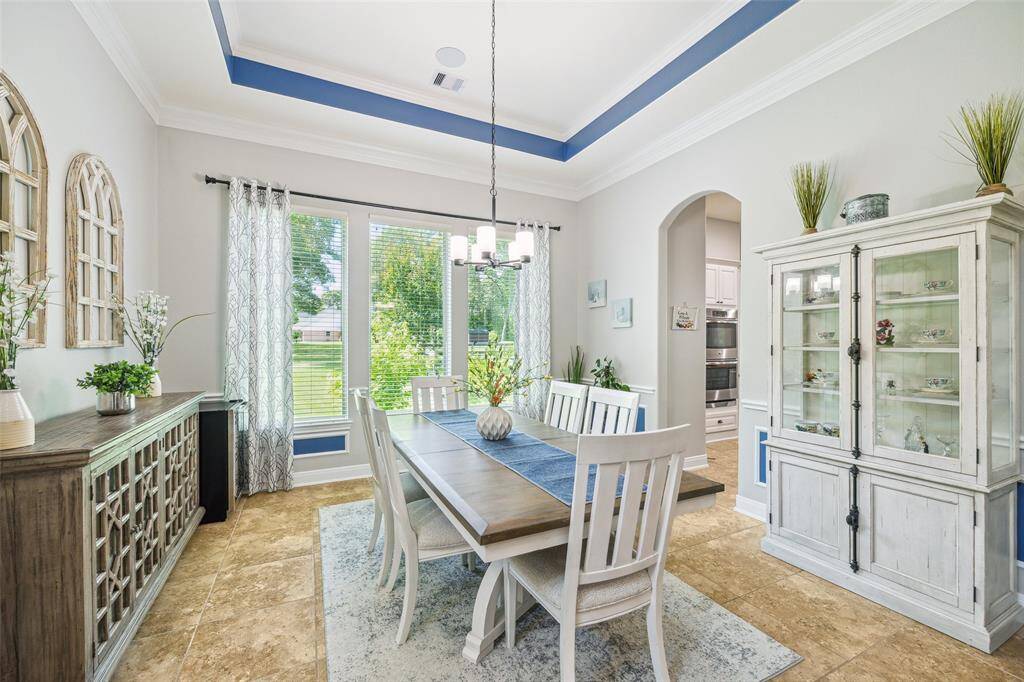 Plenty of space for a large table and decorative cabinets with large windows overlooking lush greenery.