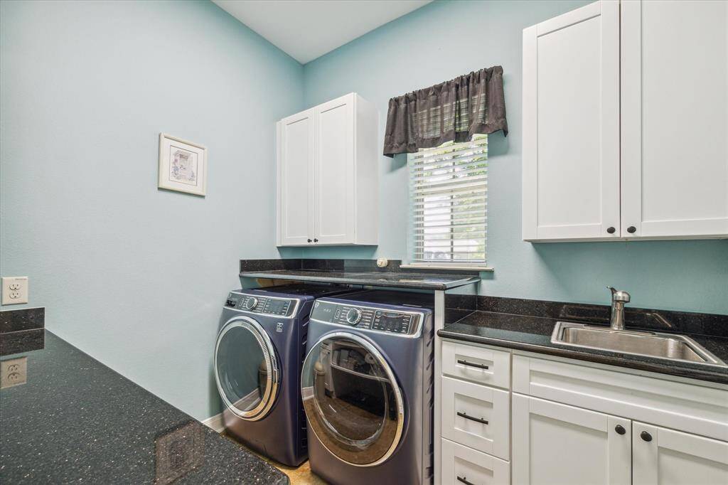 Laundry room, white cabinetry, black countertops