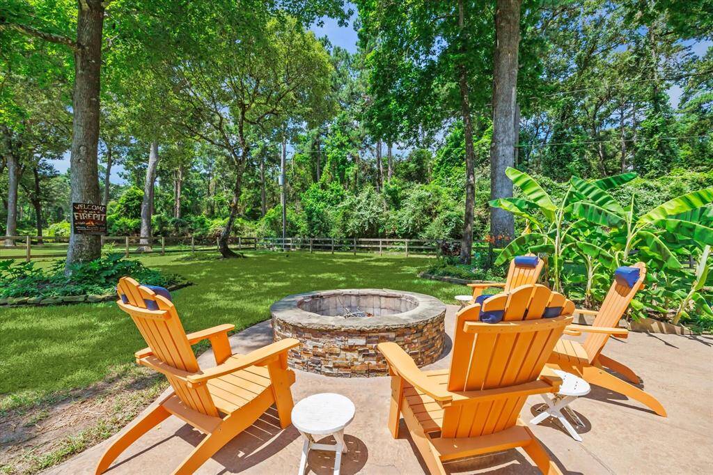 Fire pit surrounded by trees and lush greenery