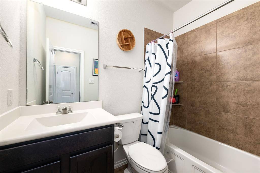 This primary bathroom is definitely move-in ready! Featuring a tub and shower combo with tile surround, dark stained cabinets with light countertops, high ceilings, custom paint, sleek and modern finishes.