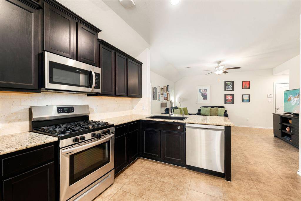 This stunning kitchen displays such a beautiful contrast with the dark stained cabinets, granite countertops, light modern backsplash, and SS appliances, breakfast bar, recessed lighting, high ceilings and breakfast nook.