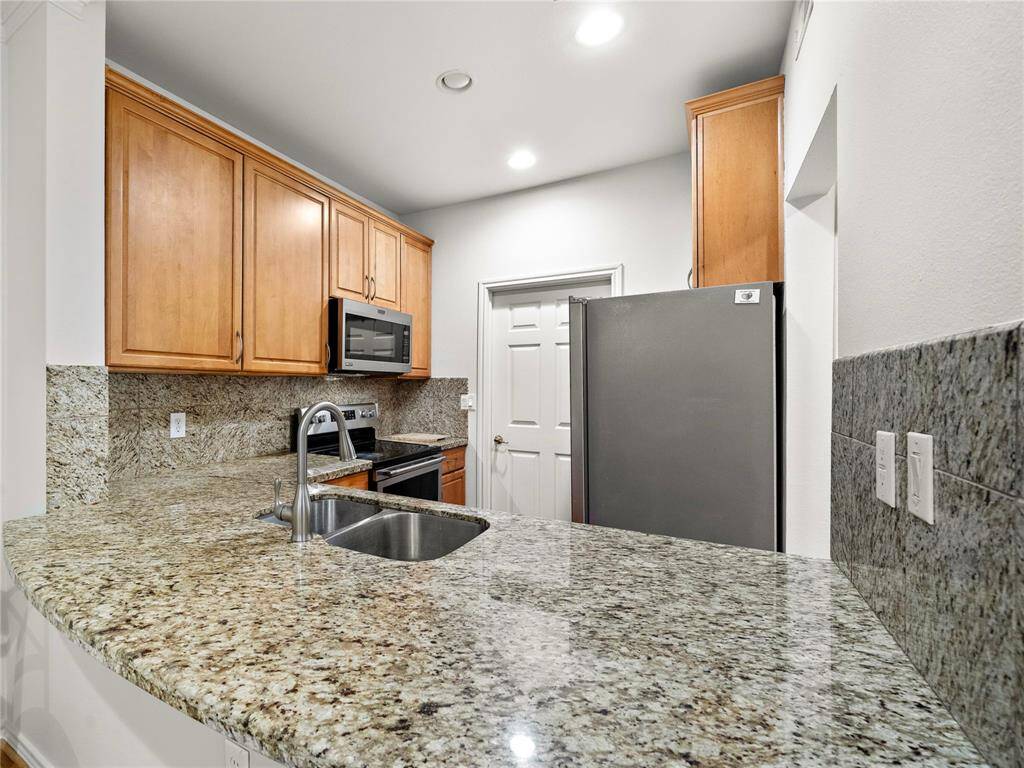 The sleek kitchen features slab granite countertops, stainless steel appliances, and ample cabinet space, making it a chef's delight.