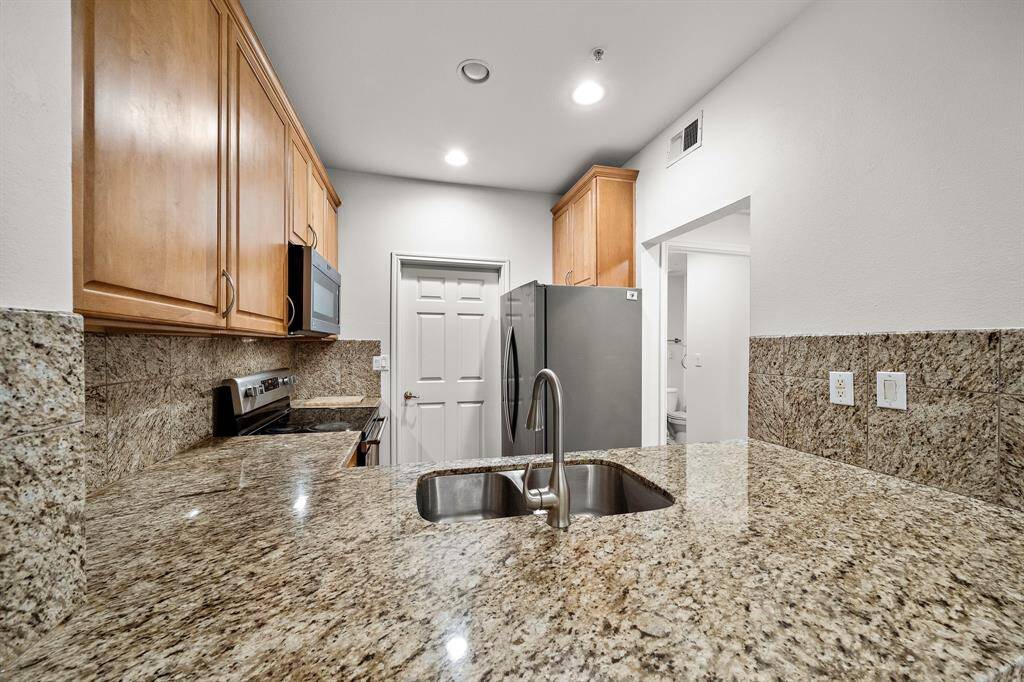 The kitchen is adorned with beautiful slab granite countertops that offer plenty of space for meal prep and casual dining.