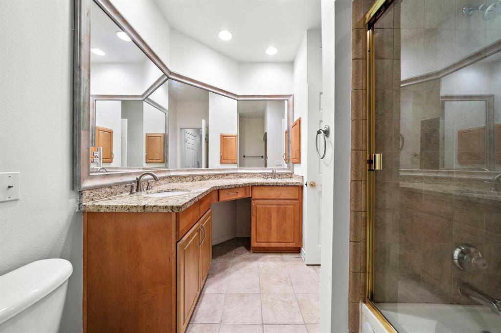 The primary bath features double vanities with granite countertops, offering ample space for morning routines.