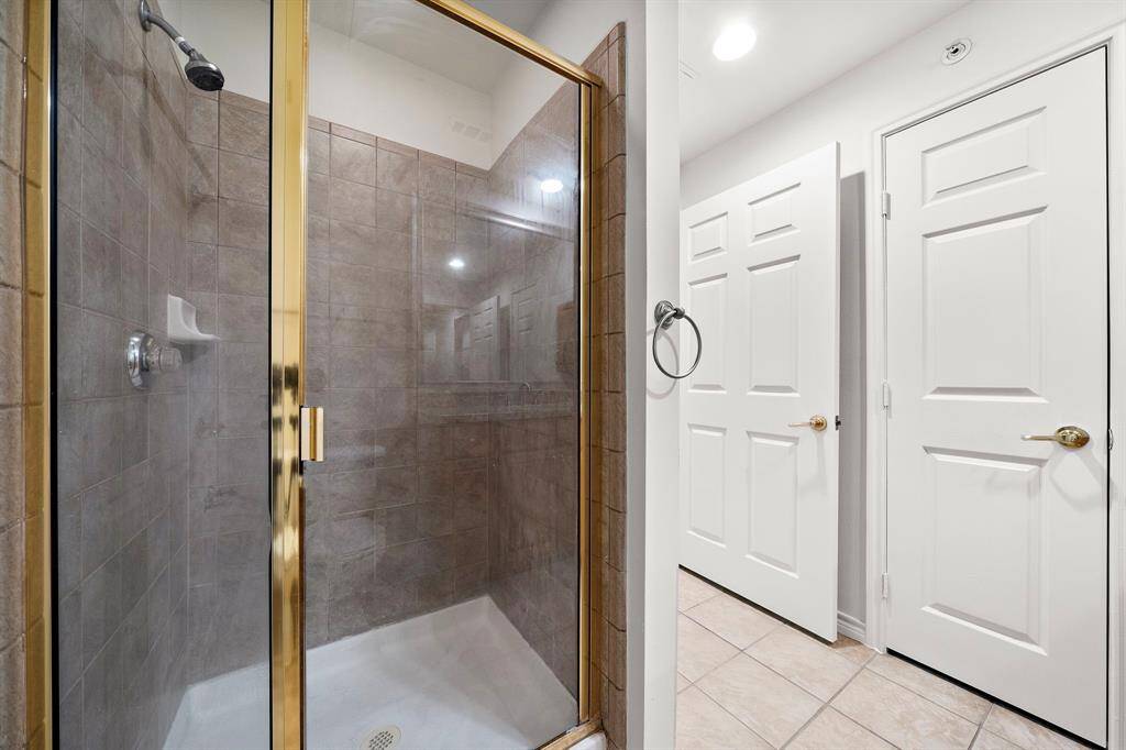 The spacious walk-in shower is finished with stylish tile, offering a refreshing retreat at the end of the day.