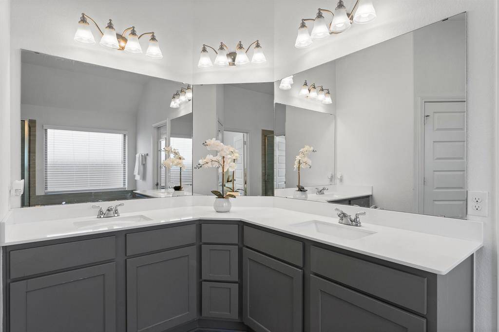 Plenty of good storage cabinet space in this primary bathroom. It receives good natural lighting as well.