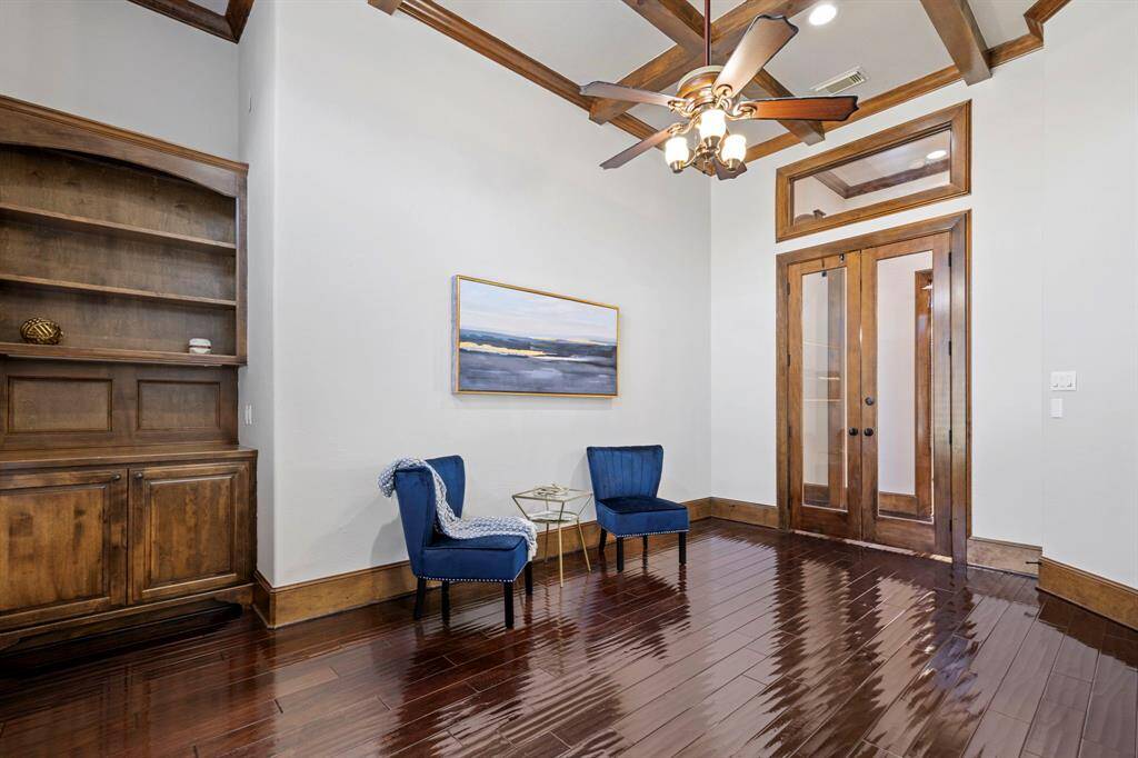 Another view of the study with built-ins, beams and french glass doors