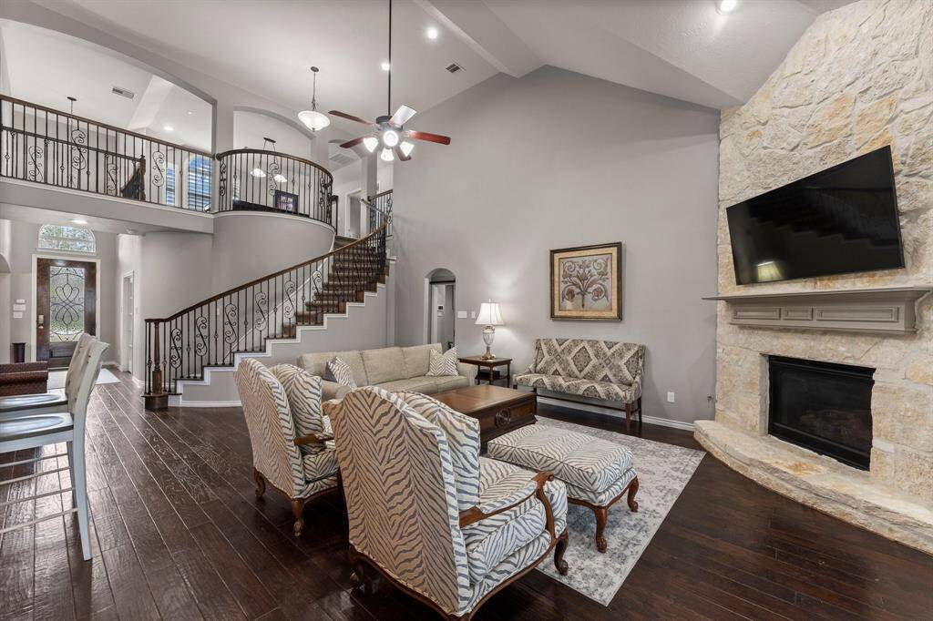 View of the beautiful curved staircase and hallway leading to the laundry room, powder bath, and Primary suite.