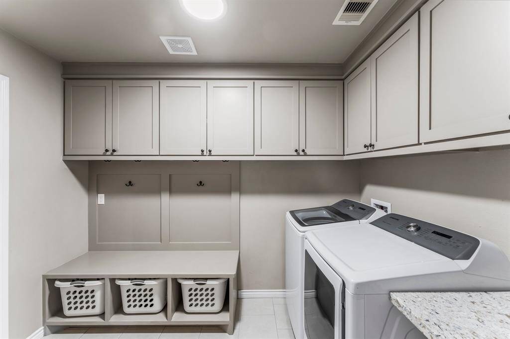 The laundry room features custom built in cabinets.