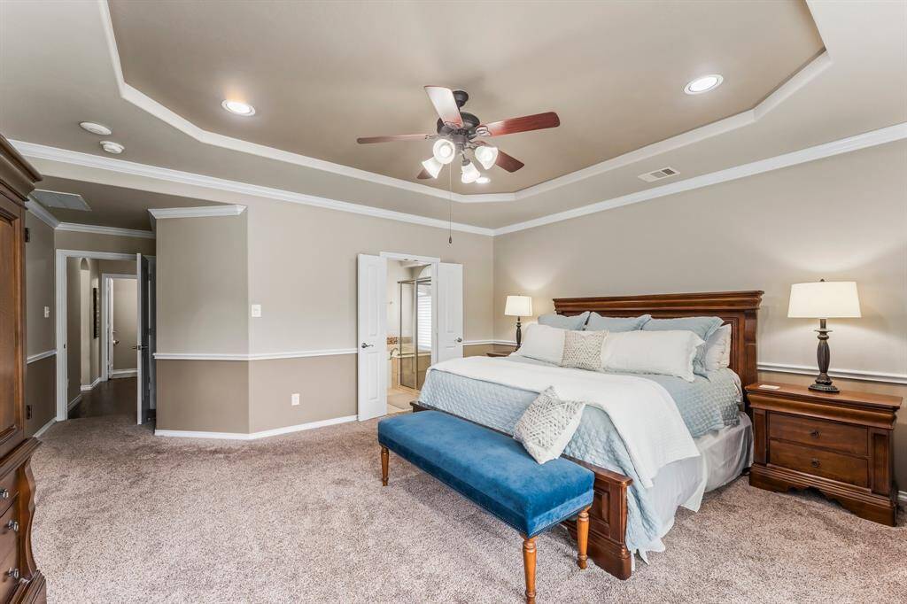 The primary suite is huge and features a tray ceiling and plenty of lighting.