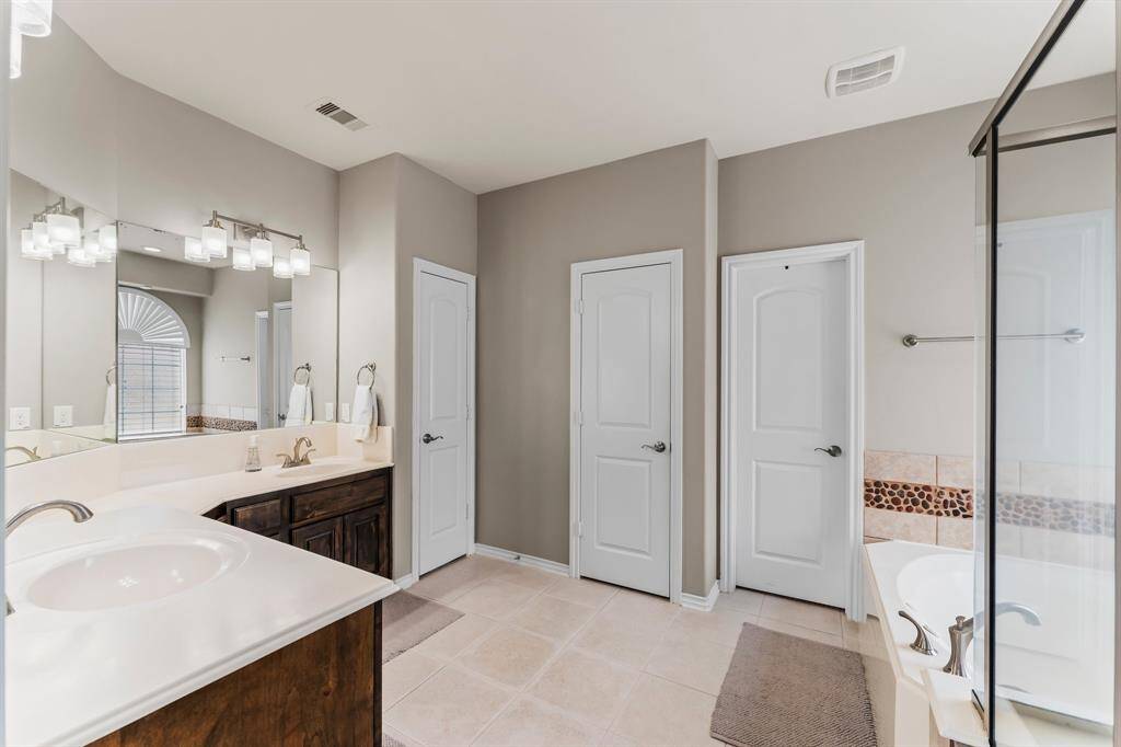 The Primary bathroom is an owner's retreat featuring 2 sinks, a vanity area, walk in shower and large jet tub!