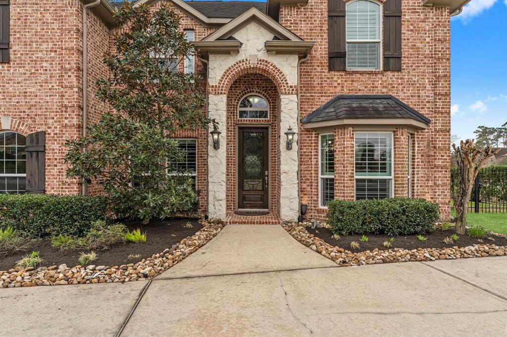Gorgeous exterior with a two story entrance surrounded by brick and stone.