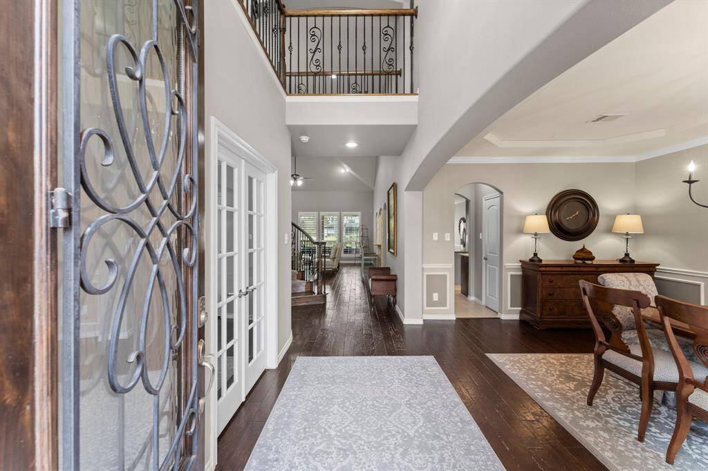 Stunning 2-story foyer with formal dining to the right and private home office on the left.