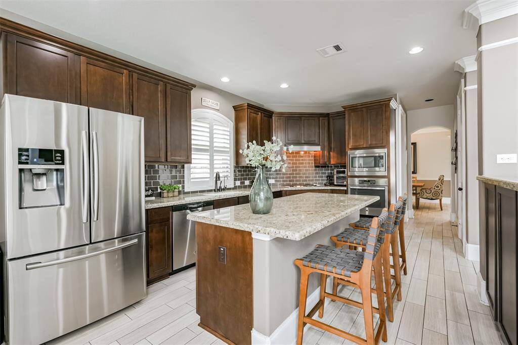 Chef's Eat-In Island Kitchen Features Granite Countertops, Stainless Steel Appliances and 42" Cabinets with Crown Molding