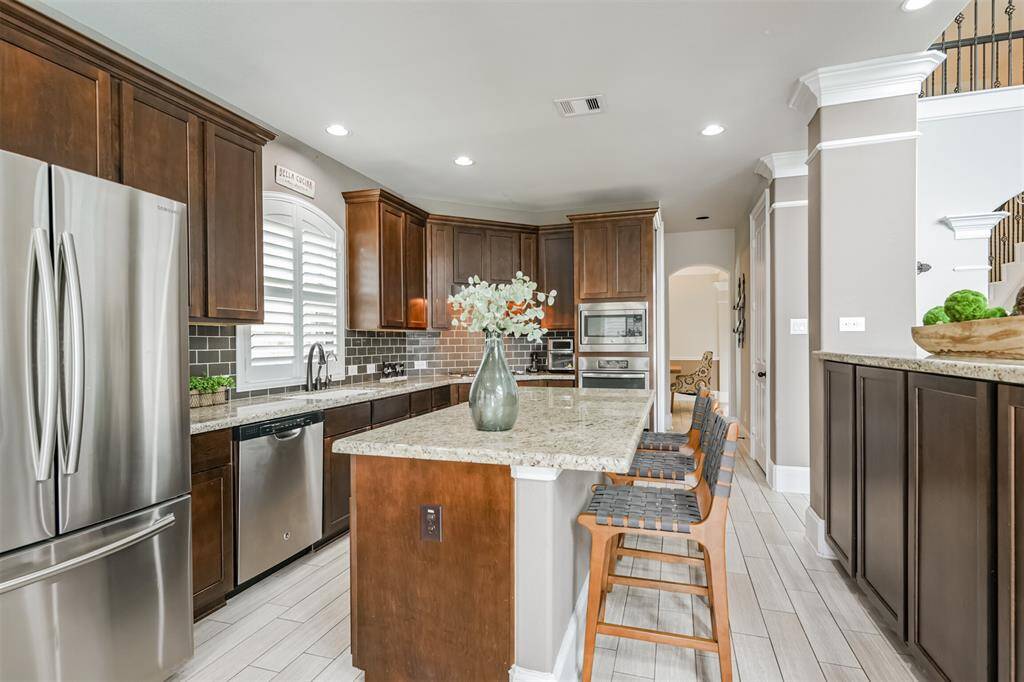 Chef's Eat-In Island Kitchen Features Granite Countertops, Stainless Steel Appliances and 42" Cabinets with Crown Molding