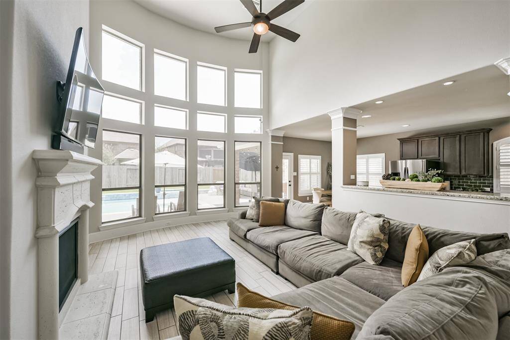Living Room Features Soaring Ceilings, A Wall of Windows Illuminating the Home with Morning Light, Built-In Cabinetry and a Fireplace