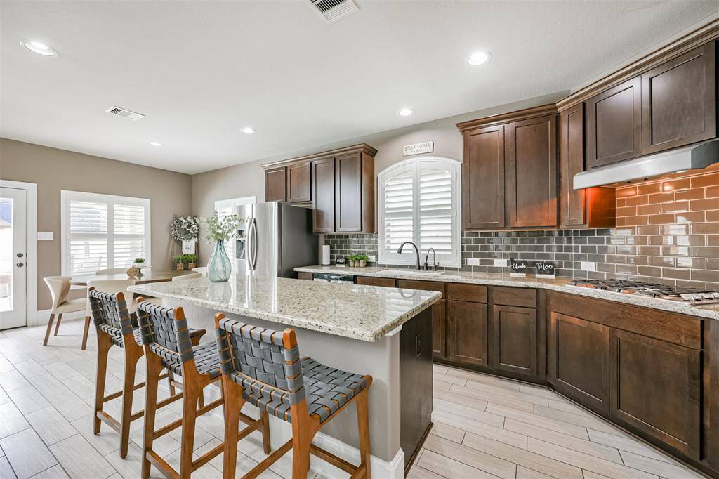 Chef's Eat-In Island Kitchen Features Granite Countertops, Stainless Steel Appliances and 42" Cabinets with Crown Molding