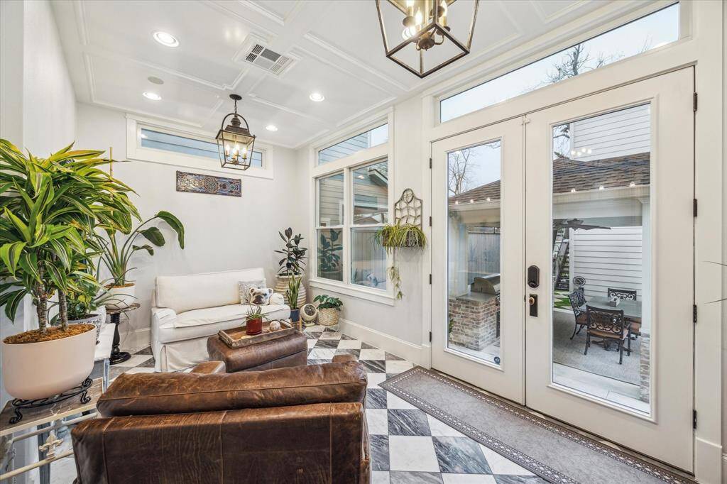 Beautiful sunroom, added in 2023, featuring elegant Italian Carrera tile, recessed lighting and charming lanterns. It's the perfect space to relax and enjoy serene views of the backyard.