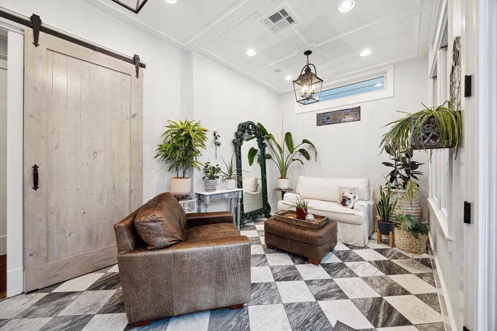 Beautiful sunroom, added in 2023, featuring elegant Italian Carrera tile, recessed lighting and charming lanterns. It's the perfect space to relax and enjoy serene views of the backyard.