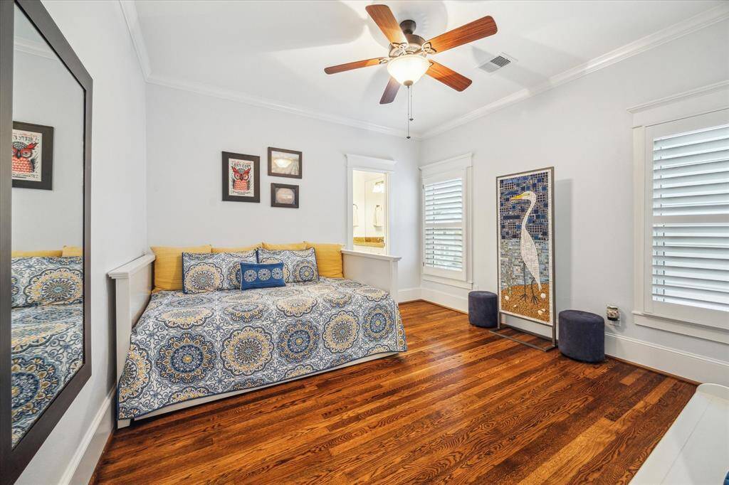 Third bedroom with hardwood floors, crown molding, plantation shutters, walk-in closet and direct access to a bathroom.
