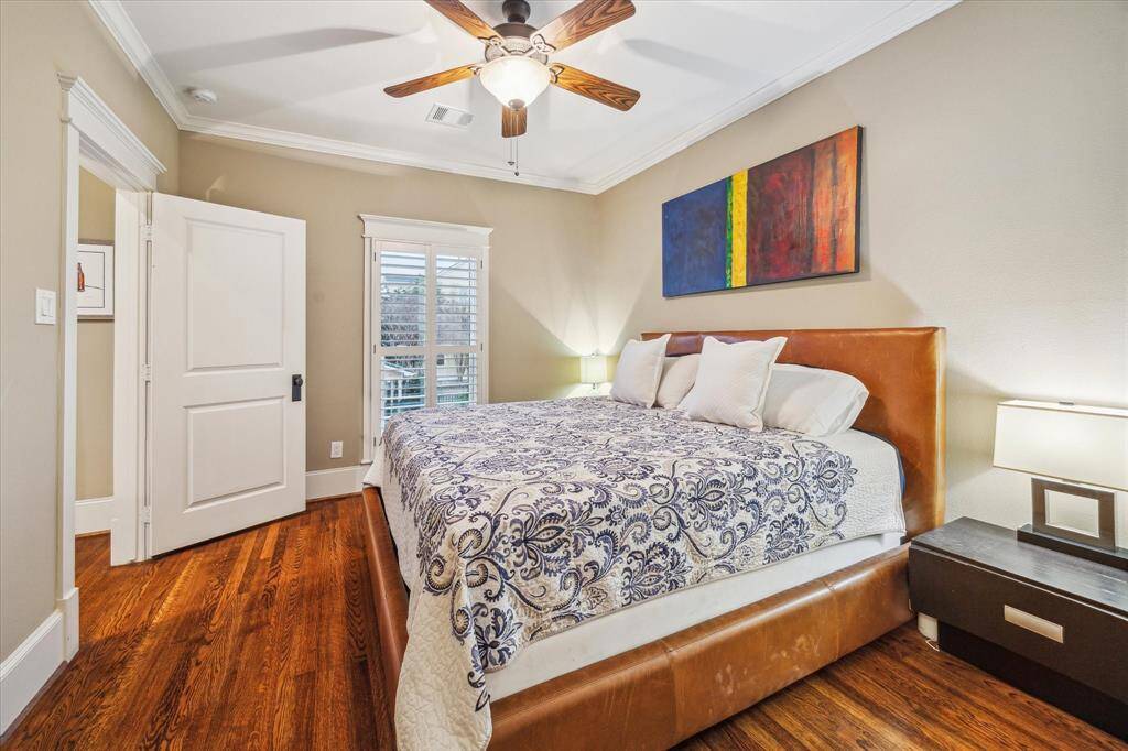 Bedroom in the garage apartment boasts hardwood floors, ceiling fan, walk-in closet and ensuite bath.