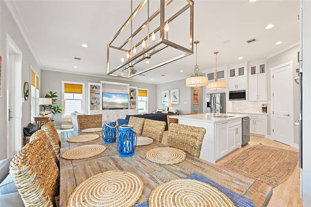 Make entertaining a breeze, cooking in the gorgeous chef's kitchen to serving in the dining area and crashing on the couch to enjoy company!  From this angle you see the floor to ceiling cabinetry with shaker cabinets and lighted shelving with glass doors on top.  The nice sized pantry is great for an owners closet or to store all of your essentials.